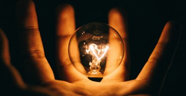 Lightbulb in a hand with darkness background | Photo by Rohan Makhecha on Unsplash