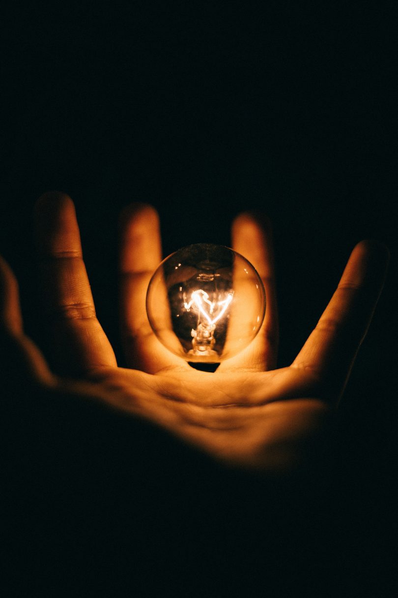 Lightbulb in a hand with darkness background | Photo by Rohan Makhecha on Unsplash