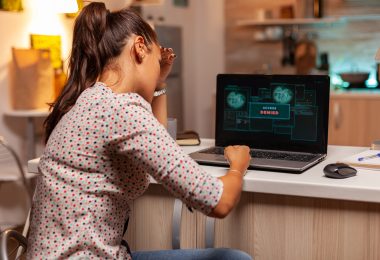 Angry hacker woman because of access denied while trying to attack government firewall. Programmer writing a dangerous malware for cyber attacks using performance laptop during midnight.