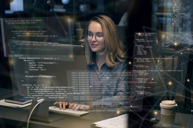 Picture of white woman with glasses coding with heads up display of FOSS code user interface overlaid